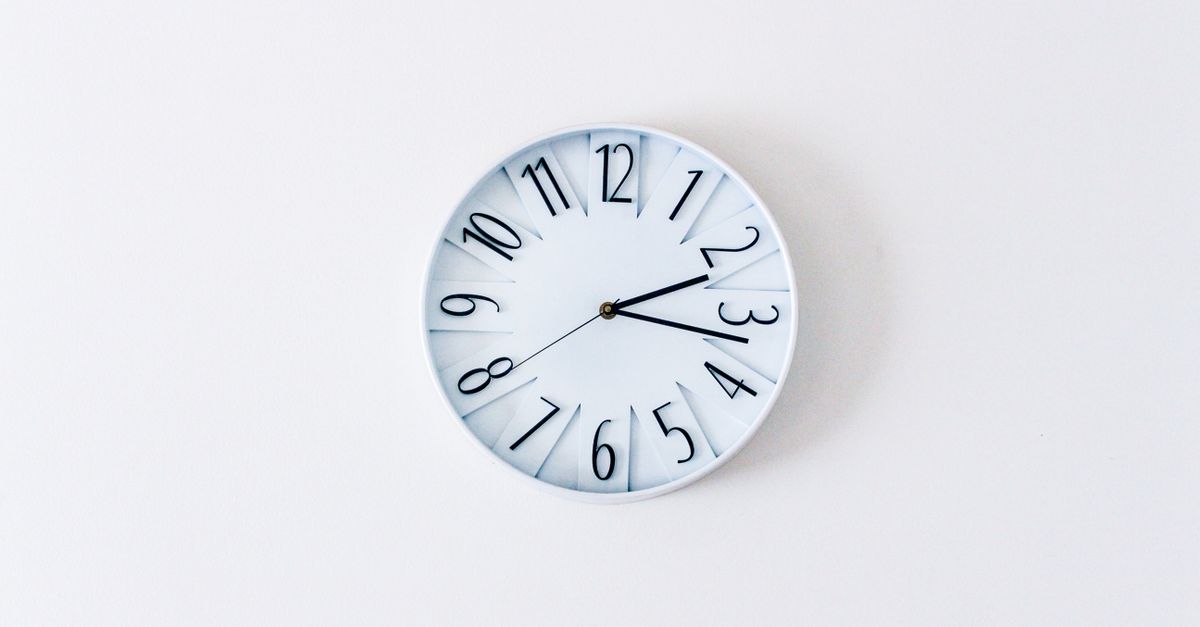 Plain white wall clock marking the ten minutes an egg transfer appointment usually takes