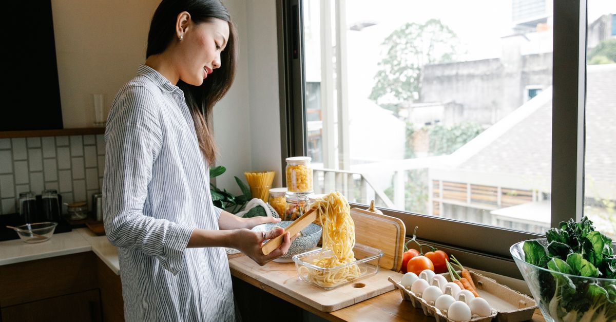 Woman preparing food at a bright kitchen counter during the wait after an embryo transfer